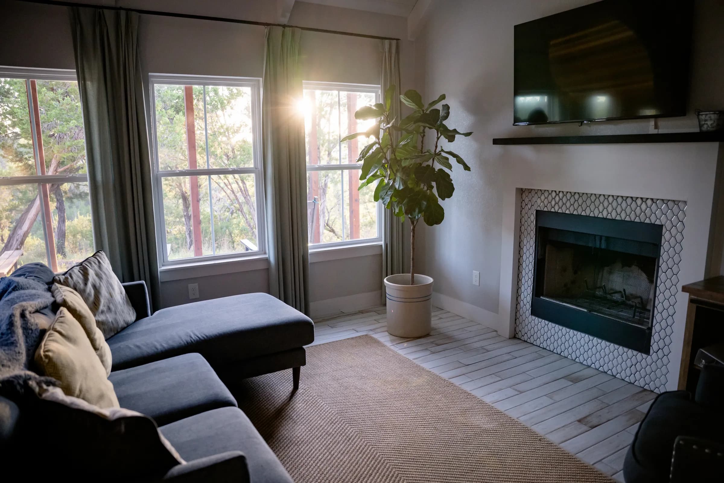 Sunlit sitting area by the fireplace inside a Wayside Wimberley farmhouse cottage