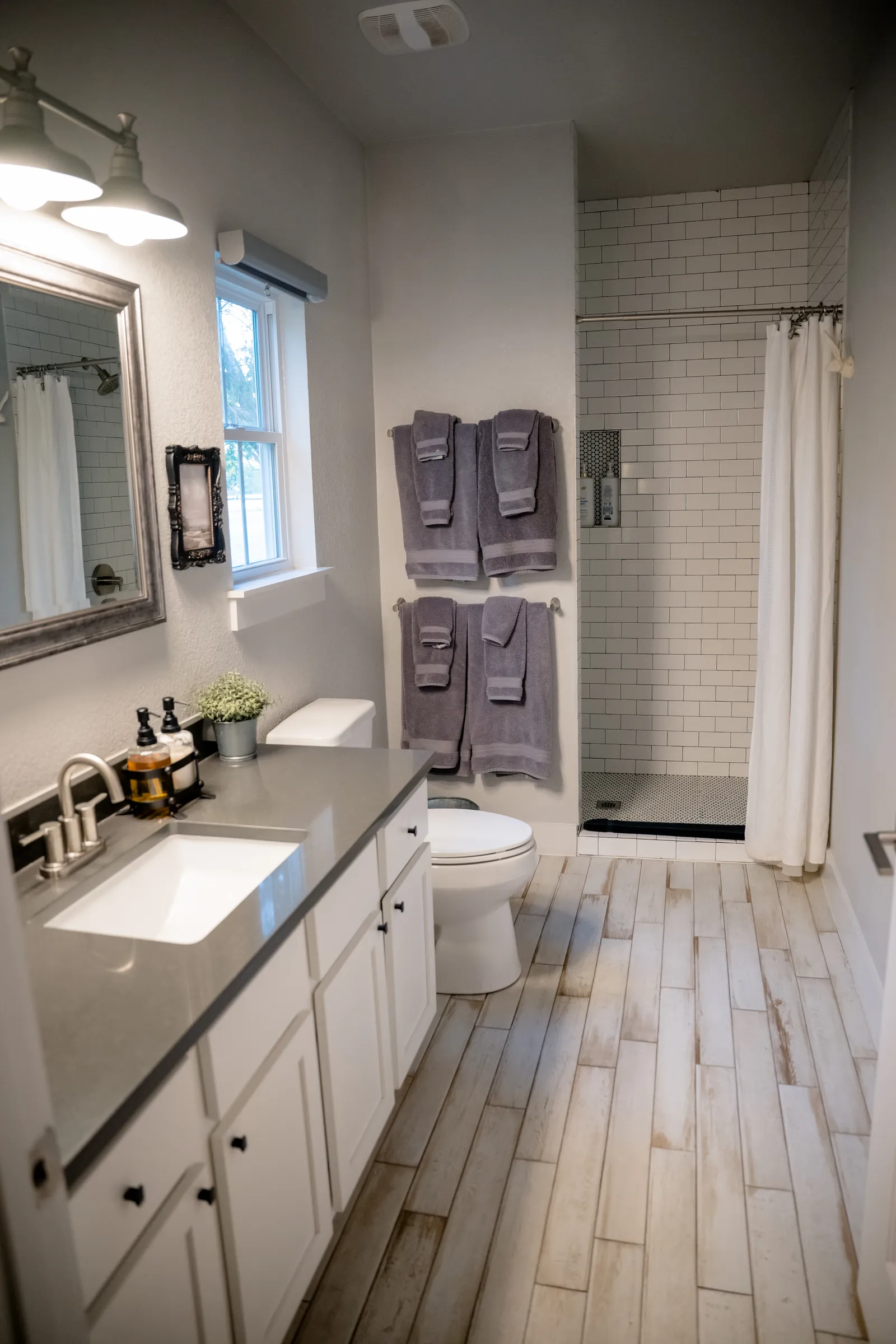 Farmhouse bathroom with walk-in shower and double vanity in Summermoon Cottage