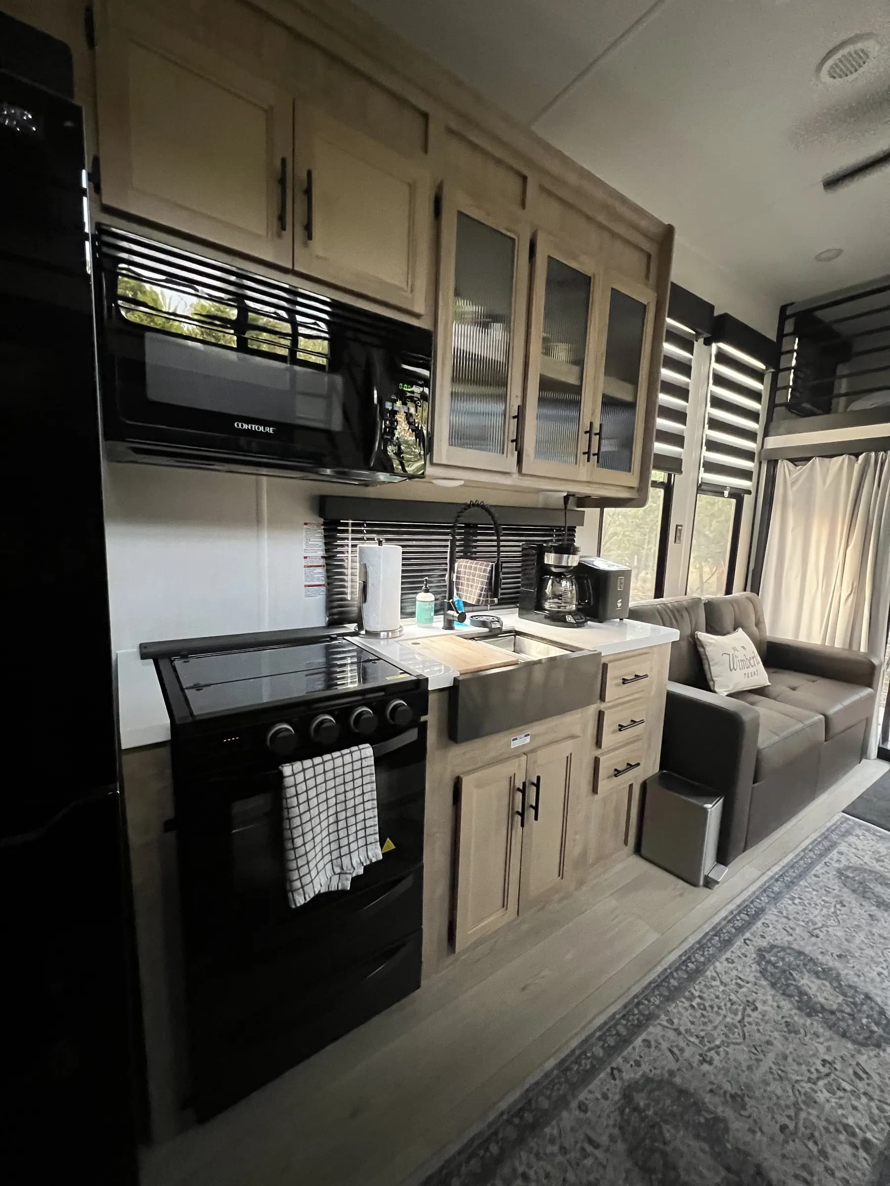 Full kitchen with range and microwave inside Blancobreeze glamping RV