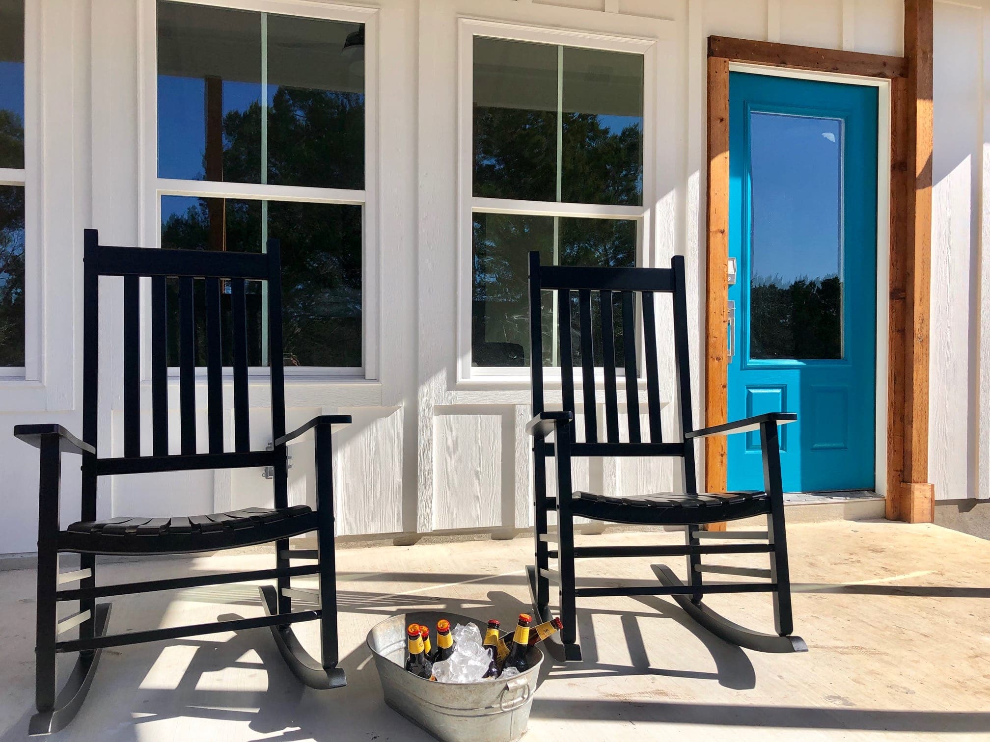 Rocking chairs on the Jackrabbit Cottage porch with blue door