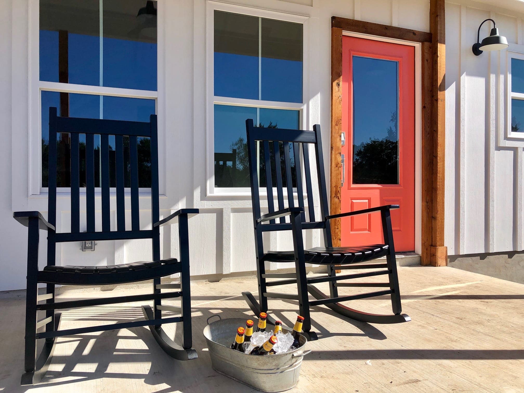 Rocking chairs on the Summermoon Cottage porch with pink door