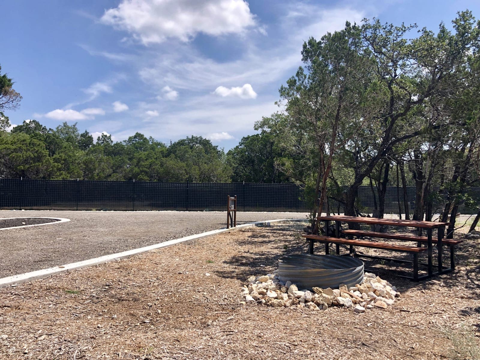 Picnic table and fire pit at an RV site at Wayside Wimberley