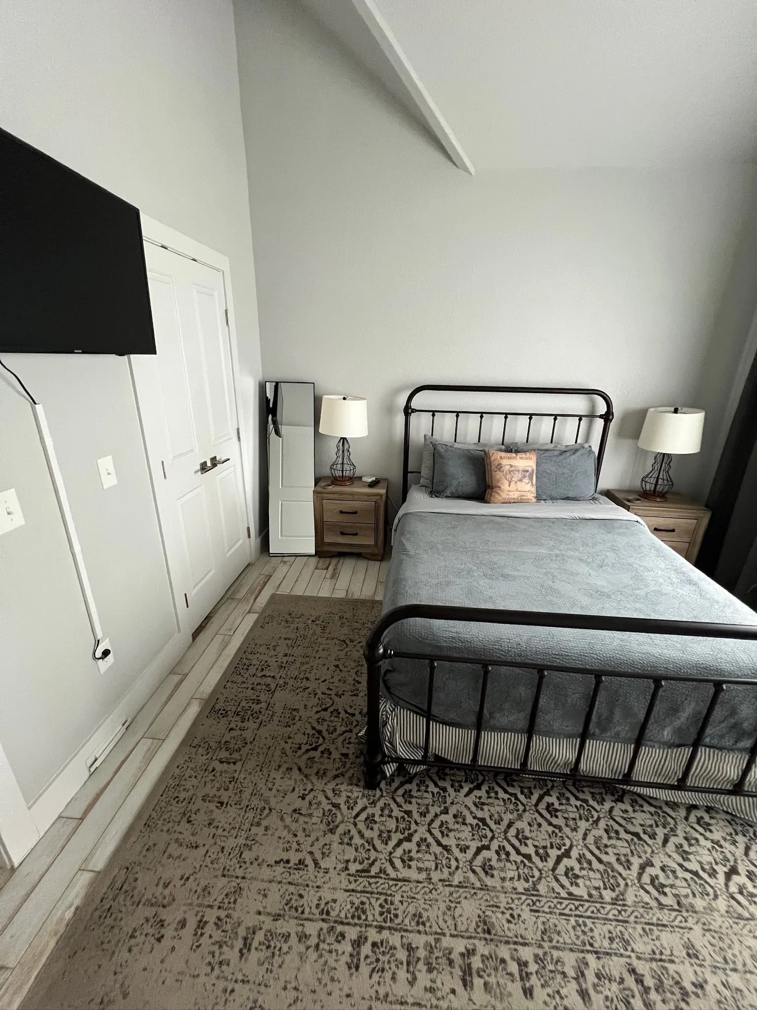 Summermoon Cottage bedroom with black iron bed and vaulted ceiling