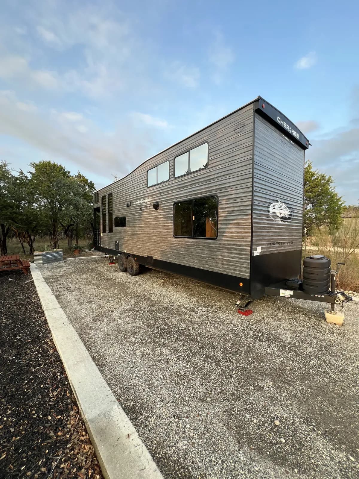Blancobreeze Cherokee Timberwolf glamping RV on its gravel site at Wayside Wimberley