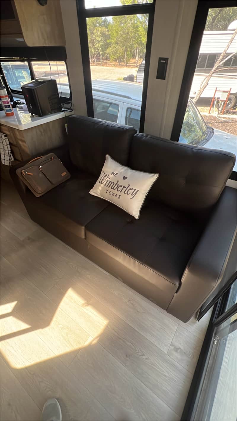 Living area with sectional couch inside BlancoBreeze glamping RV