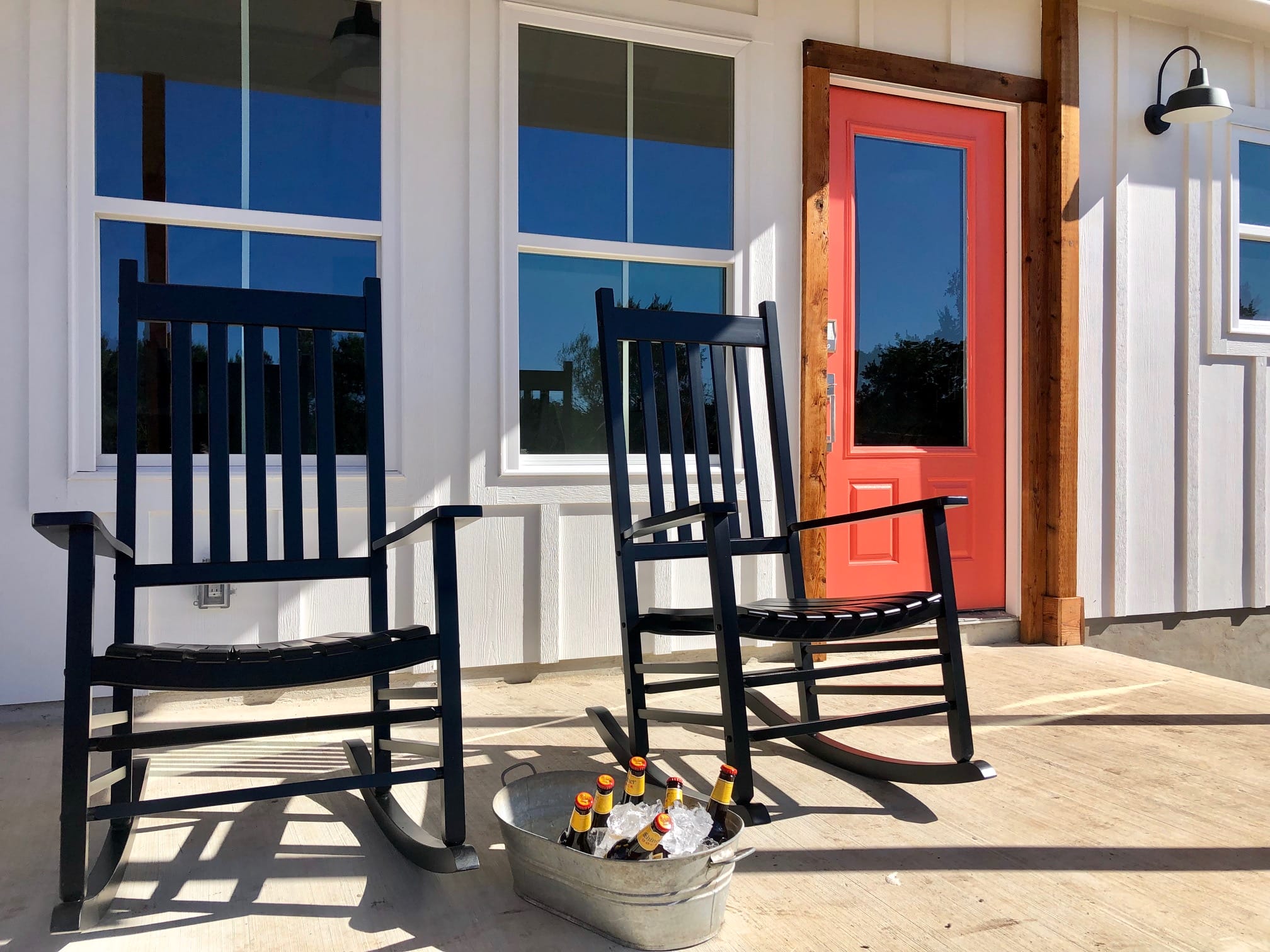 Rocking chairs on the Summermoon Cottage porch with pink door